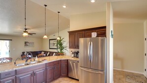 A modern kitchen with granite countertops, stainless steel appliances, and dark wood cabinets.