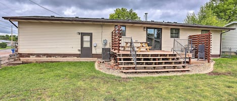 A single-story mobile home with a front porch, a small deck, and a front yard.