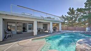En swimmingpool med ett täckt uteområde, utomhusmöbler och en inhägnad terrass.