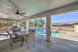 An outdoor patio with a table and chairs, a ceiling fan, a pool, and a grill. - Family-friendly Lake Havasu Getaway w/ Deck & Pool (Lake Havasu City)