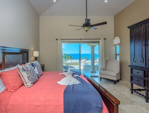 A hotel room with a bed, a chair, a cabinet, and a view of the ocean. - Cabo Hacienda w/ Private Pool & Rooftop Terrace! (Cabo San Lucas)