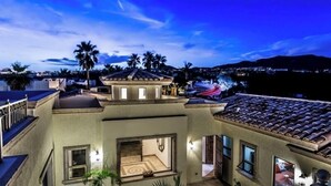 A multi-story building with a rooftop terrace, large windows, and a view of the surrounding landscape. - Cabo Hacienda w/ Private Pool & Rooftop Terrace! (Cabo San Lucas)
