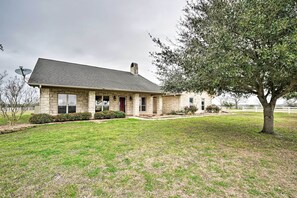 Charming single-story house with a gabled roof and chimney, featuring a front entrance and windows on both levels.