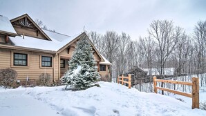 A wooden lodge with a snow-covered roof, a snow-laden tree, and a wooden fence. - 2 Mi to Schuss Mtn! Northern Retreat w/ Game Room (Bellaire)