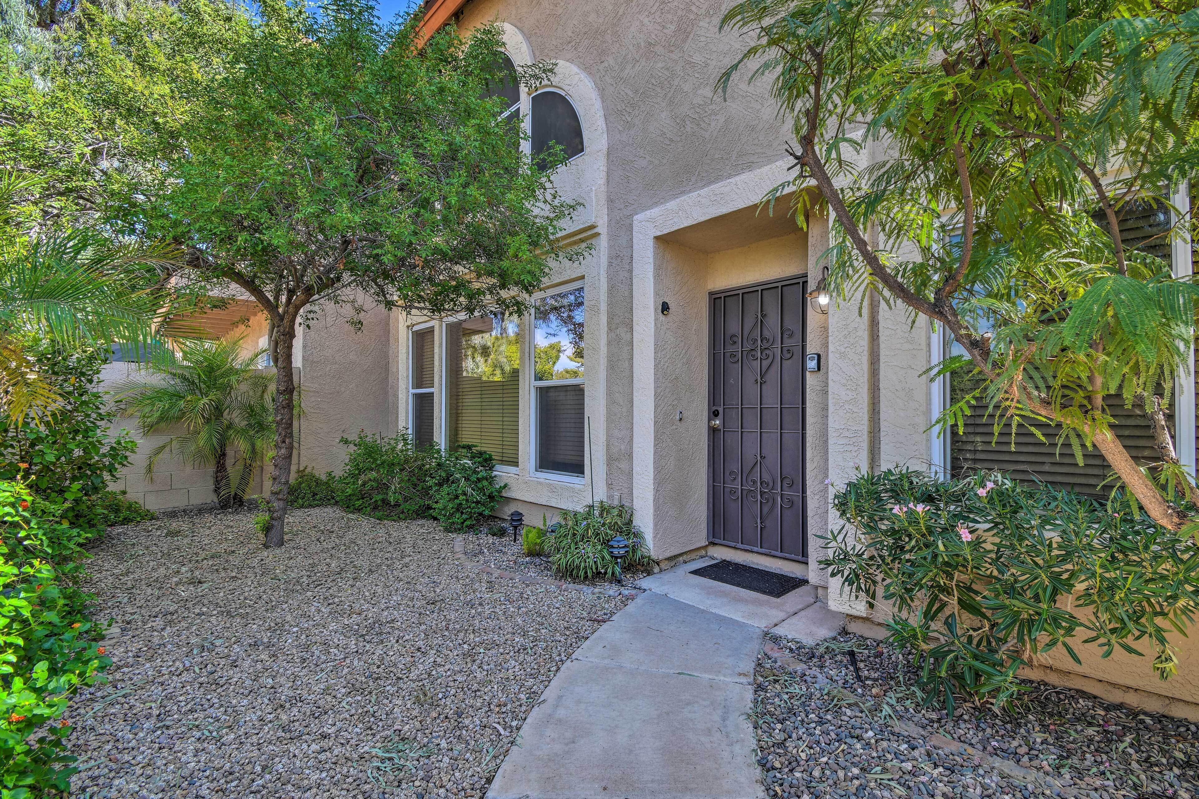 A building with a stucco exterior, a concrete pathway, and a gated entrance.