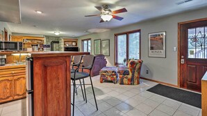 A spacious kitchen with wooden cabinets, a bar area, and a ceiling fan.