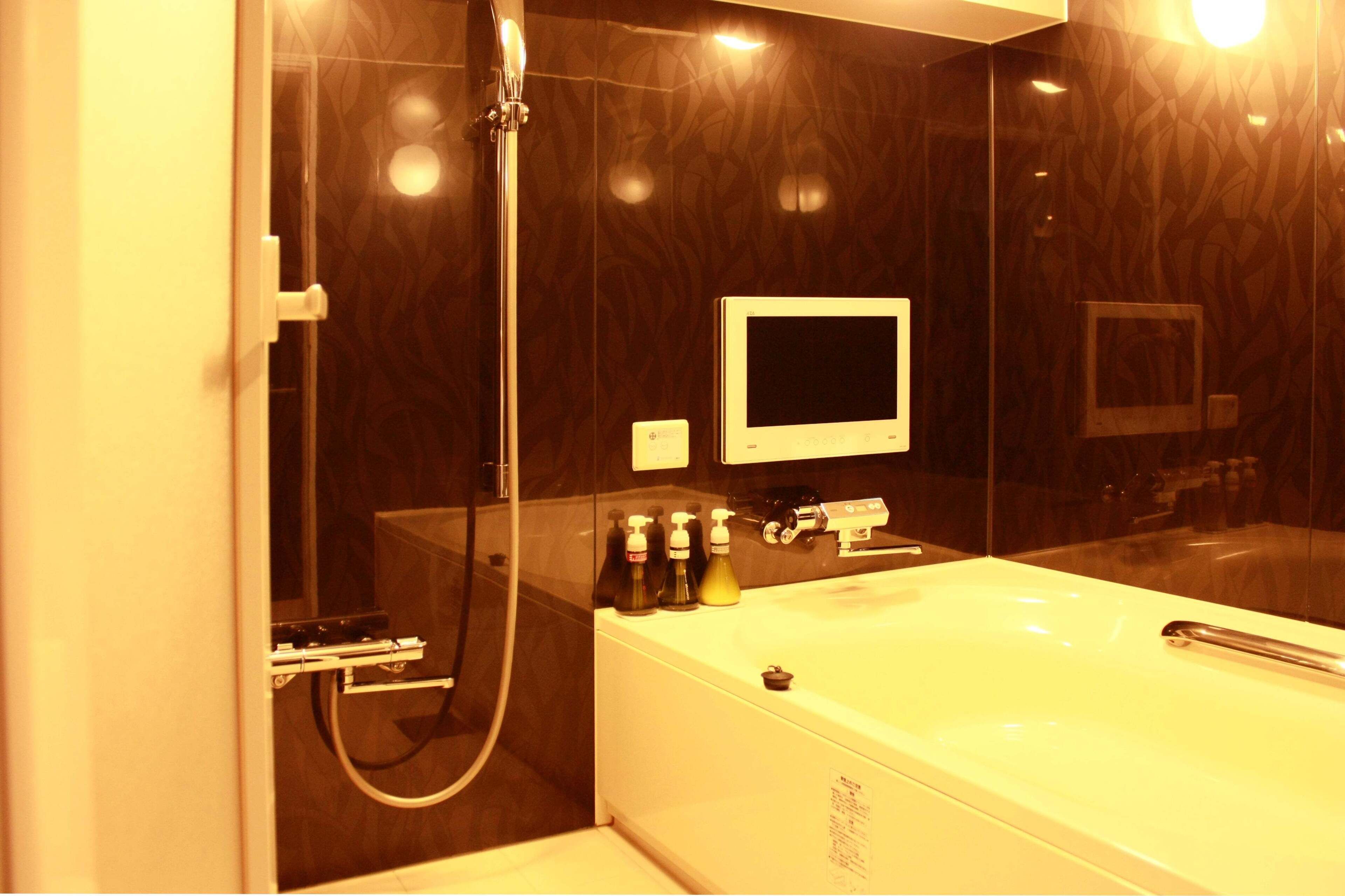 A modern bathroom with a glass-enclosed shower, a large bathtub, and a mirror above the sink.