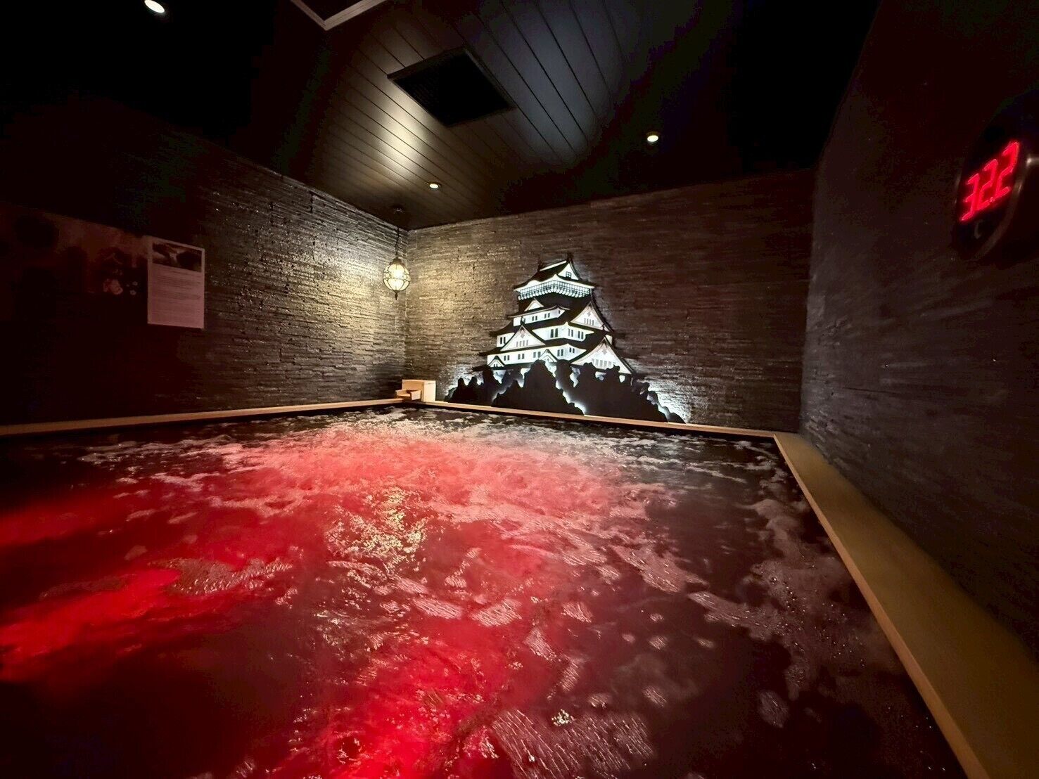 A room with a red-lit floor, a mural of a traditional Japanese building, and a digital clock displaying '322'.