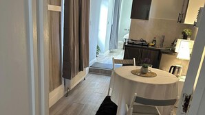 A compact living space with a dining area, kitchenette, and a view of the outside. - 1-Bed - Sleeps 2 - Acton Park & Stn Close (London)