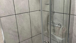 A glass-enclosed shower with a handheld showerhead, tiled walls, and a visible control panel. - 1-Bed - Sleeps 2 - Acton Park & Stn Close (London)