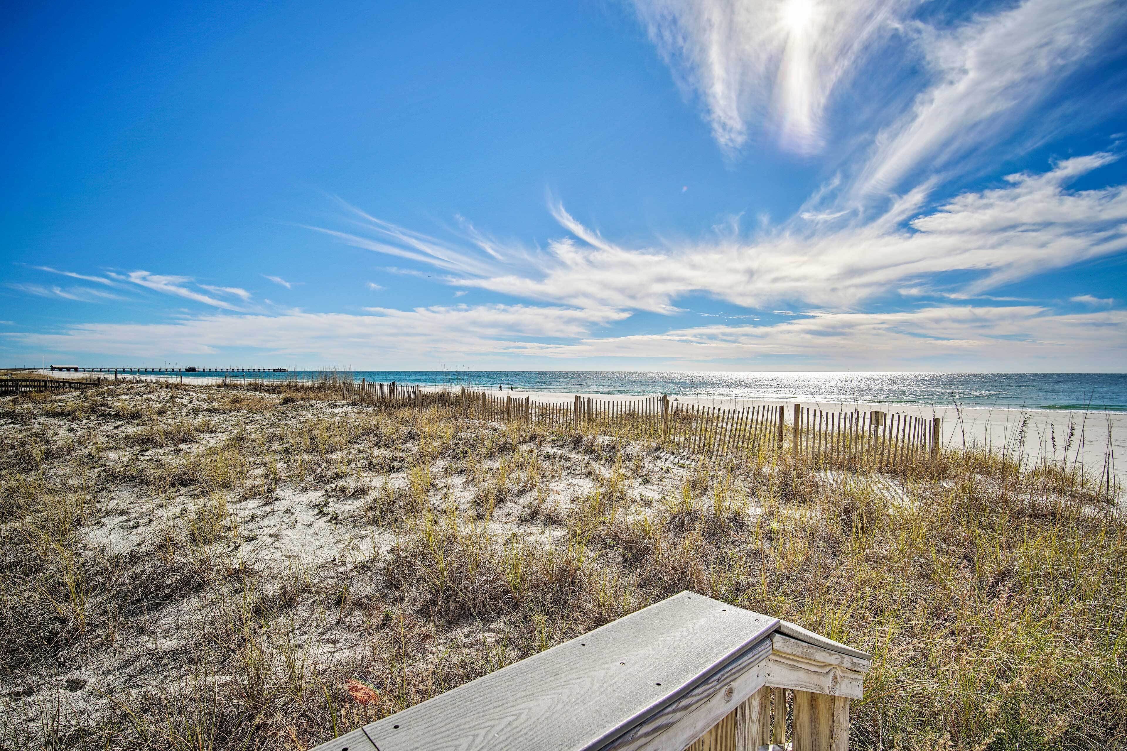 A beach with a wooden fence and a wooden structure in the foreground.