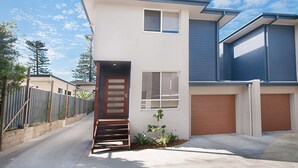 A modern two-story house with a front door, a small porch, and a garage. - LUXURY HAVEN! Beautiful, central, wifi & spacious! Walking to everything! (Yamba)