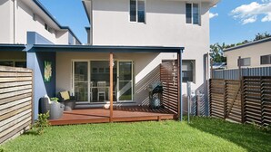 A modern two-story house with a covered patio, a staircase leading to the upper floor, and a fenced backyard. - LUXURY HAVEN! Beautiful, central, wifi & spacious! Walking to everything! (Yamba)