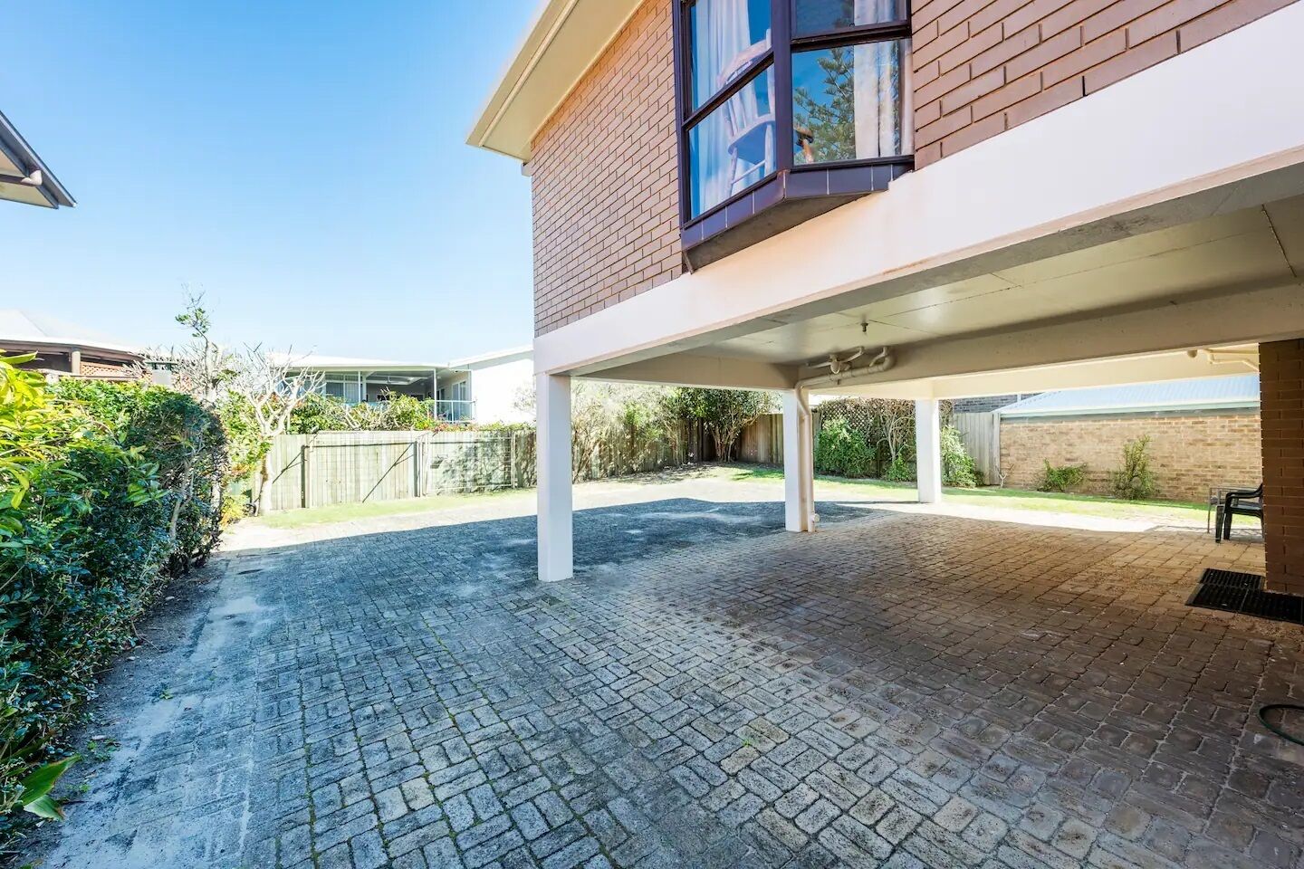 A covered outdoor area with a brick wall and a window.