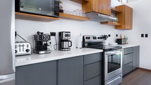 A modern kitchen with a built-in microwave, toaster, coffee maker, and oven. - Coral House, 5 min to the beach-  fiber optic internet and swimming pool  (Uvita)