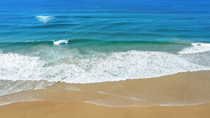 Una playa con agua azul cristalina y olas.