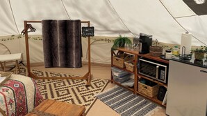 A cozy tent interior with a sleeping area, a coffee station, and storage shelves. - 4200ft Luxury Stargazing Glamping Haven, Ultra-Private, Near BRP (Maggie Valley)