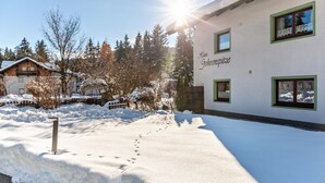 Eine verschneite Außenanlage mit einem Gebäude, auf dem 'Haus Gehrenspitzle' steht.