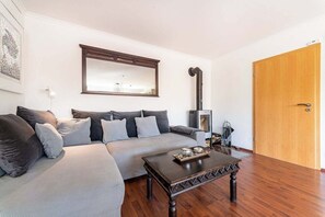 A living room with a sofa, a coffee table, a fireplace, and a wooden door.