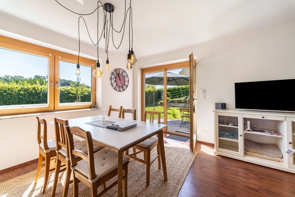 A dining area with a table, chairs, and a view of the outdoors.