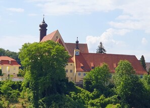 Un bâtiment doté d’une tour horlogée, d’un toit rouge et d’un clocher d’église.