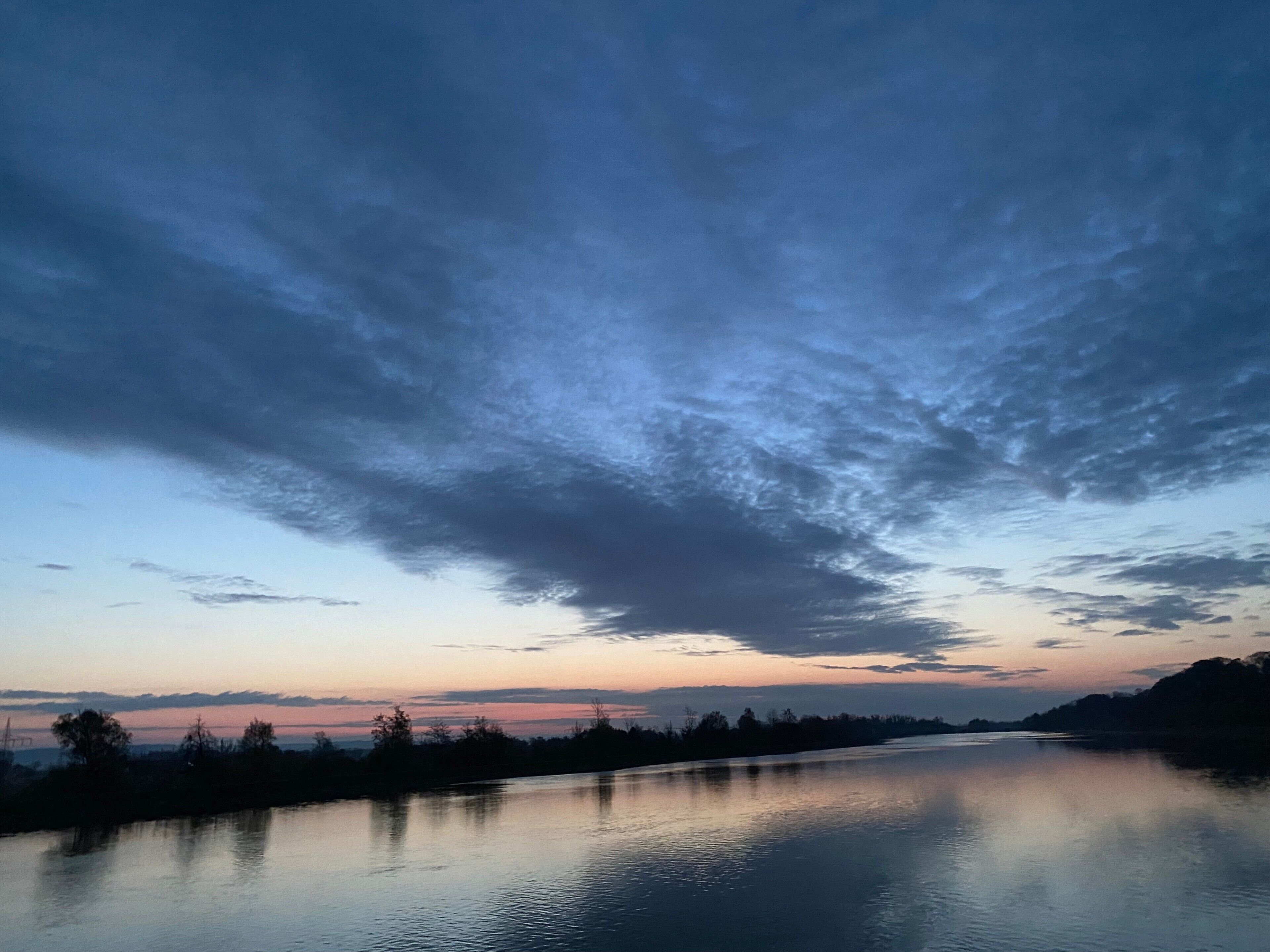 Un fiume calmo sotto un cielo nuvoloso.