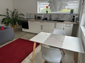 Une cuisine moderne avec un coin repas, un tapis rouge et une fenêtre donnant sur un beau paysage.