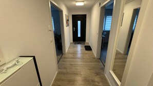 A hallway with wooden flooring, white walls, and a door at the end. - Apartment 'Alina' with Private Terrace and Wi-Fi (Sinsheim)