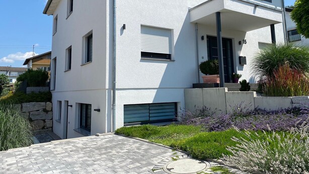 A modern two-story building with a flat roof, a balcony, and a stone wall. - Apartment 'Alina' with Private Terrace and Wi-Fi (Sinsheim)