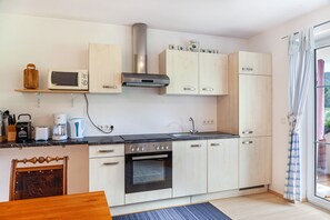 Une cuisine moderne équipée d’un four à micro-ondes, d’un four et d’une machine à café.