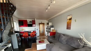 A modern living space with a kitchen, dining area, and a staircase. - Apartment 'Klug' with Mountain View, Private Terrace and Wi-Fi (Schonach im Schwarzwald)