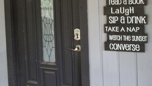 A black door with a frosted glass window and a sign listing porch rules. - Cozy lake house w/Lake Conroe access- pet friendly! (Montgomery)