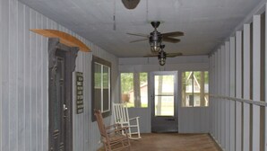 A room with wooden flooring, a ceiling fan, and a door with a sign. - Cozy lake house w/Lake Conroe access- pet friendly! (Montgomery)