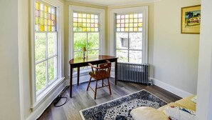A room with a wooden table and chair, a radiator, and a patterned rug. - Warren Vacation Rental, Walk to Warren Town Beach (Warren)