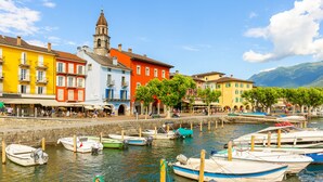 A waterfront with colorful buildings, a church tower, and boats docked along the shore. - Serenata Room 2 - Cavigliano Studio with Terrace for 3, Cavigliano, Centovalli, Switzerland (Cavigliano, Centovalli)