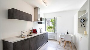Una cocina moderna con estufa integrada, un lavaplatos y un comedor con mesa y sillas.