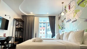 Una habitación de hotel con una cama grande, un escritorio, un televisor y un mapa en la pared.