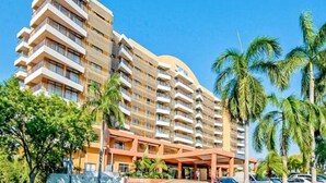 A multi-story hotel with balconies, a curved facade, and a covered entrance area. - ZEN88 ESPLANADE - Hotel Suite Ocean View (Darwin)