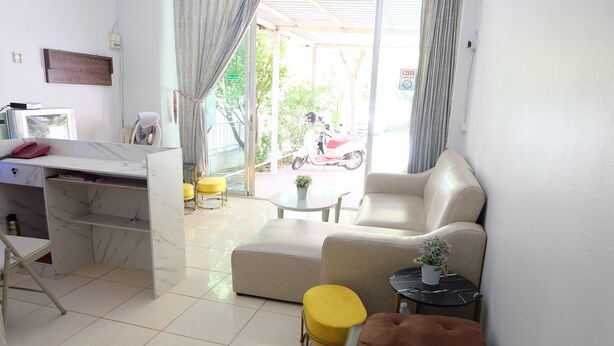 A modern living room with a sofa, ottoman, and a small table with a plant. - POP 75429 101 Place Navanakorn (Khlong Luang)