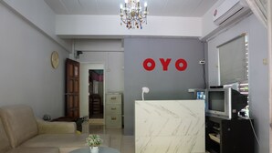 A modern living room with a beige sofa, a marble reception desk, and a television on a stand. - POP 75429 101 Place Navanakorn (Khlong Luang)