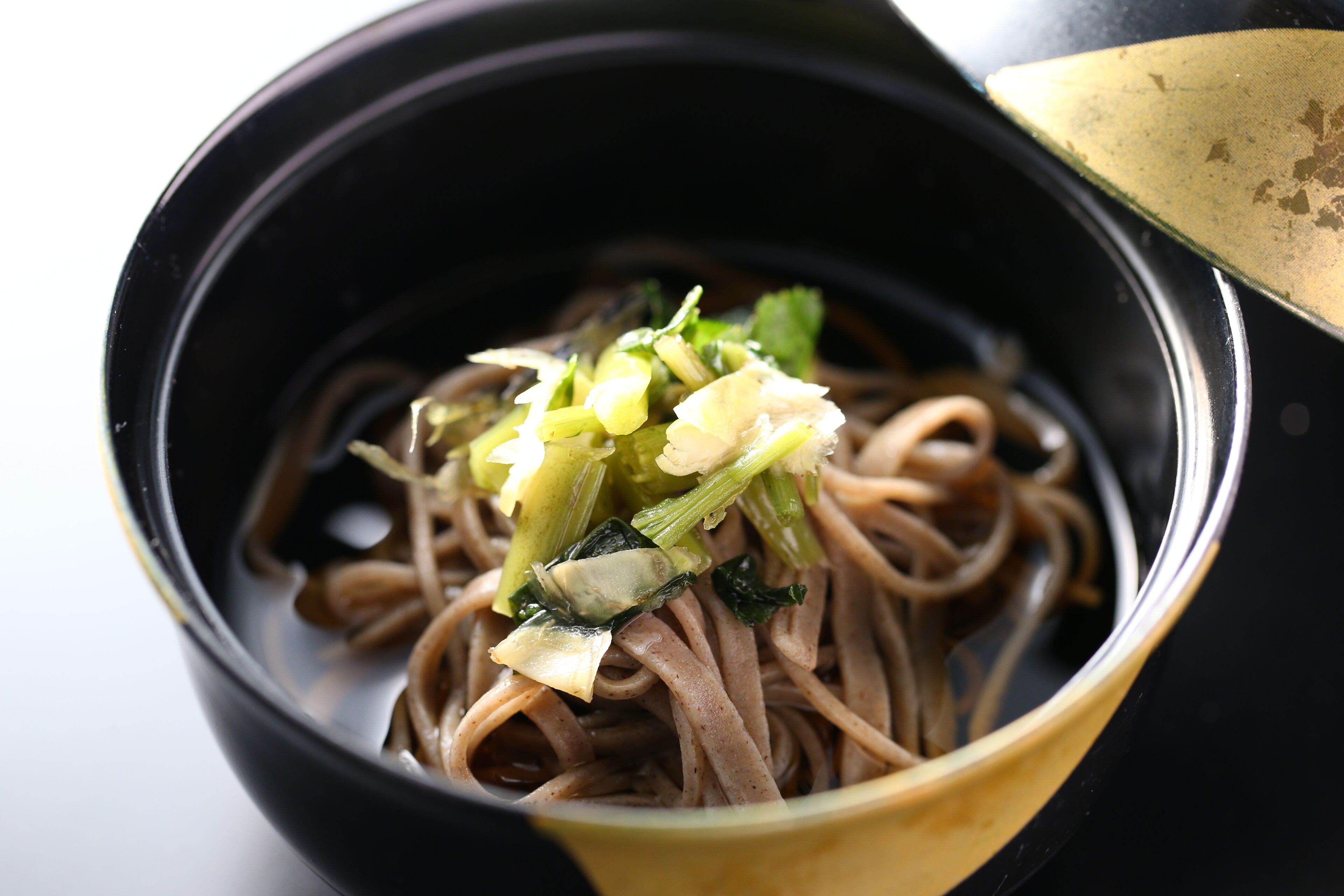 A bowl of noodles with vegetables.
