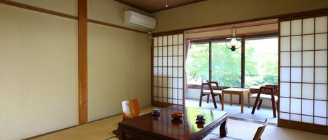 Una habitación japonesa tradicional con suelo de tatami, una mesa de madera y puertas correderas shoji.
