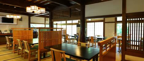 A traditional Japanese-style restaurant with tatami mat flooring, wooden furniture, and sliding doors.