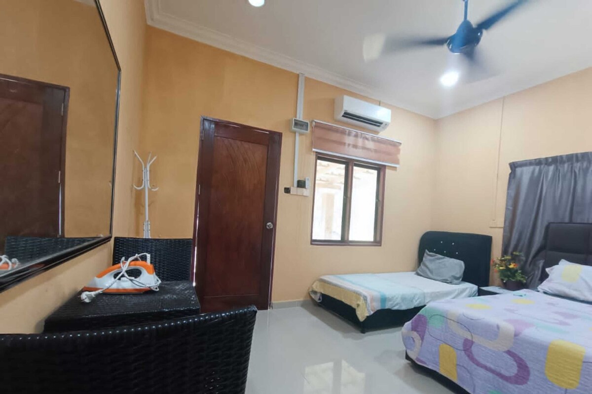 A hotel room with two beds, a ceiling fan, an air conditioning unit, a window, and a door.