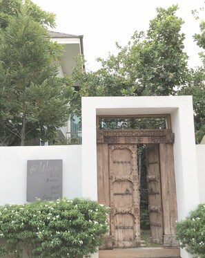 A rustic wooden door with a white wall and a signboard indicating a bed and breakfast with a price of 298.88.