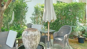 En terrasse med fletmøbler, en stenplanter og et vandfald.