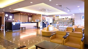 A hotel lobby with a reception desk, seating area, and a bar. - HOTEL GRANDSPA AVENUE (Asakura)