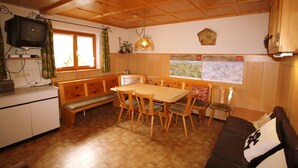 Una cocina acogedora con muebles de madera, una mesa de comedor y un banco.