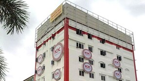 Een meerhoog gebouw met een opvallend 'KK'-logo op elke verdieping, wat duidt op een hotel of vergelijkbare gelegenheid.