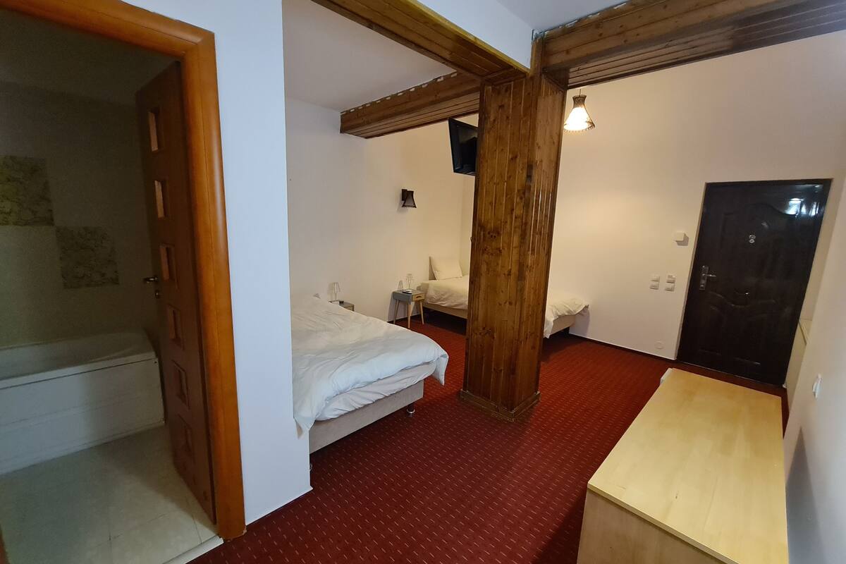 A compact room with a bed, a desk, and a wardrobe.